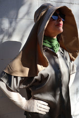 Woman wearing a beige Sun Safe hat that covers face and shoulders, sun safe gloves, sun safe neck scarf and sunglasses on.
